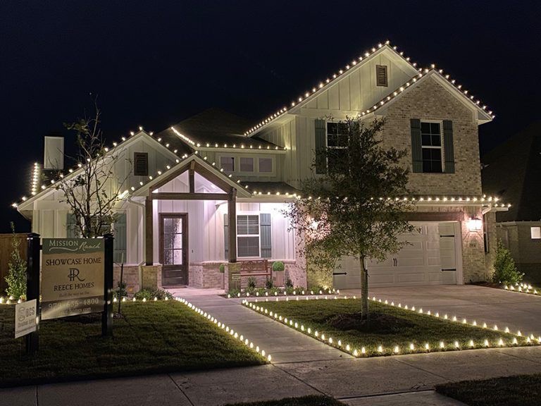 Showcase home with roofline, porch and walkway in warm white lights