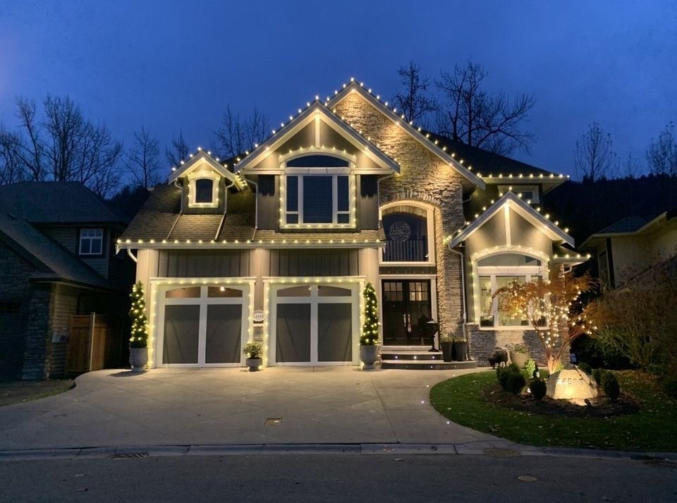 Toronto home illuminated with warm white holiday lights at dusk